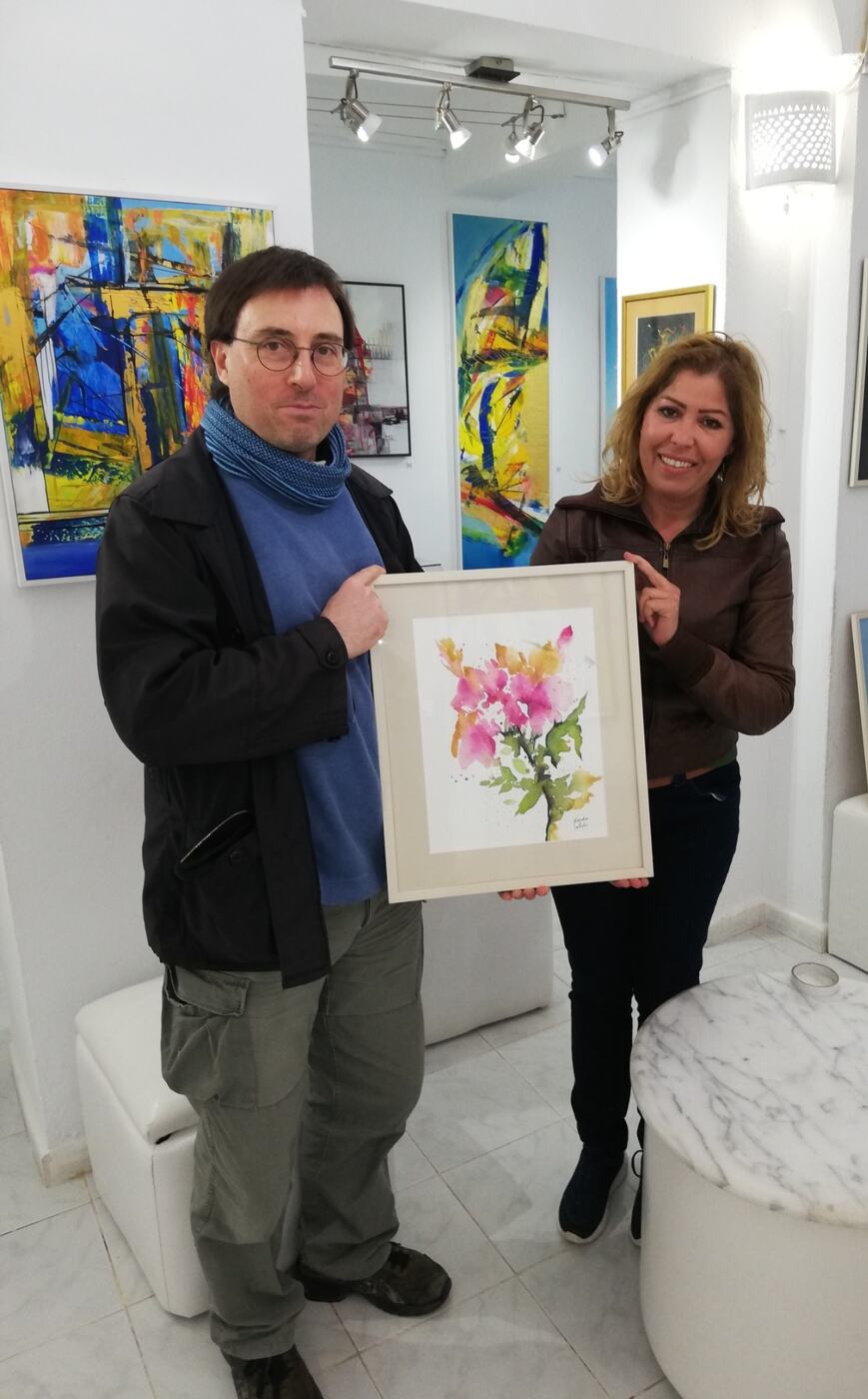 Jean-Baptiste Mesona avec l’artiste Henda Labidi tenant une œuvre à la Galerie Saladin à Sidi Bou Saïd en 2020