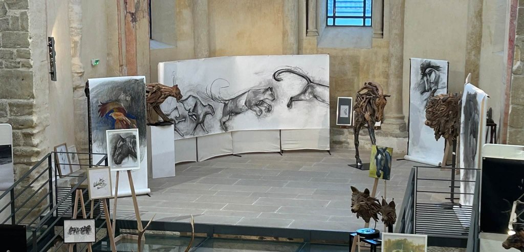 Le parcours dans la nef : fusains monumentaux, sculptures en bois flotté et dessins se répondent d'un chevalet à l'autre